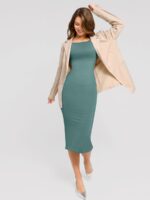 Femme en robe verte avec blazer.