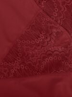 Détail de jambe dentelle rouge à bord festonné.