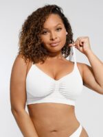 Femme en soutien-gorge blanc galbant, tenant la bretelle.
