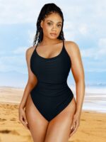 Femme en maillot noir à taille froncée sur la plage.