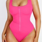 Femme en maillot zip rose, vue de face.